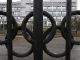Вид через забор, украшенный олимпийскими кольцами, показывает здание ФГБУ 
